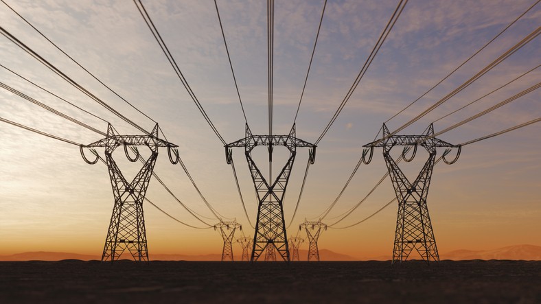 The silhouette of the high voltage power lines that uses EMi shielding, during sunset.