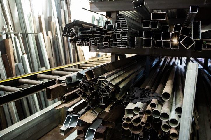 Closeup of steel shaped tubes and profiles on shelving rack in a metalworking workshop | Material Selection Strategy