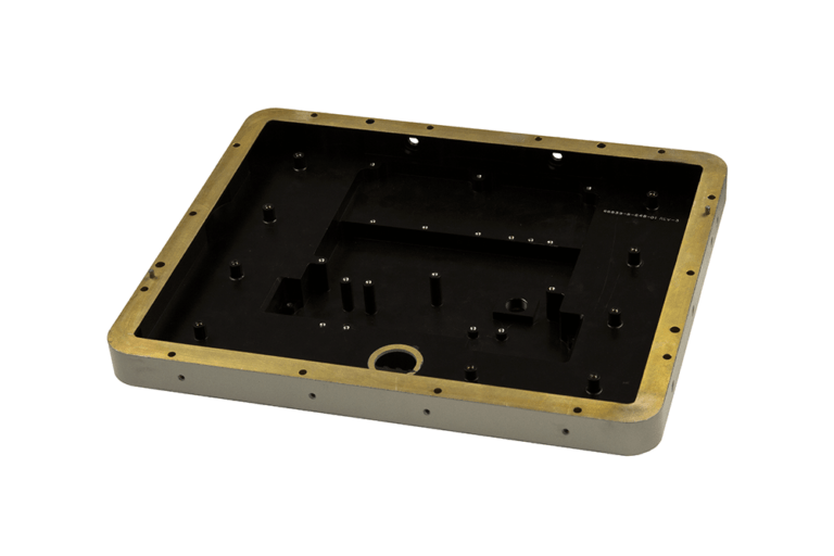 Precision-manufactured dip-brazed electronics housing base with gold chromate perimeter and anodized black interior, featuring integrated mounting bosses and strategic reinforcement structures for ruggedized defense applications.