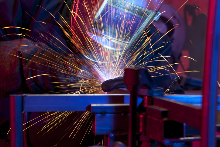 Welder erecting technical steel. Industrial steel welder in factory technical