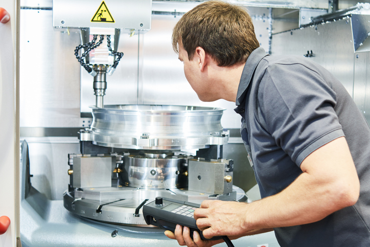 metal machining industry. Worker or service engineer operating cnc milling machine at factory